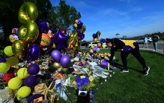 Laker fan Krystle Tamayo places a bouquet of flowers among other momentos at a makeshift memorial outside the gated community to the late NBA great Kobe Bryant's home in Newport Beach, California, on January 28, 2020. - The bodies of all nine people aboard the helicopter that crashed near Los Angeles killing NBA legend Kobe Bryant have been recovered, the coroner's office said Tuesday. Three bodies were retrieved from the wreckage by a special response team Sunday, and the remaining six on Monday, it said. (Photo by Frederic J. BROWN / AFP) (Photo by FREDERIC J. BROWN/AFP via Getty Images)