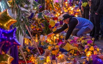 LOS ANGELES, CA - JANUARY 28: A man places a hat at a makeshift memorial near Staples Center in remembrance of former NBA great Kobe Bryant who, along with his 13-year-old daughter Gianna, died January 26 in a helicopter crash, on January 28, 2020 in Los Angeles, California. Kobe and "Gigi" were among nine people killed in the crash in Calabasas, California as they were flying to his Mamba Sports Academy in Thousand Oaks, where he was going to coach her in a tournament game.  (Photo by David McNew/Getty Images)