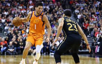 TORONTO, ON - FEBRUARY 21:  Devin Booker #1 of the Phoenix Suns dribbles the ball as Fred VanVleet #23 of the Toronto Raptors defends during the second half of an NBA game at Scotiabank Arena on February 21, 2020 in Toronto, Canada.  NOTE TO USER: User expressly acknowledges and agrees that, by downloading and or using this photograph, User is consenting to the terms and conditions of the Getty Images License Agreement.  (Photo by Vaughn Ridley/Getty Images)
