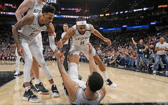SAN ANTONIO, TX - FEBRUARY 29:  Patty Mills #8 of the San Antonio Spurs and Dejounte Murray #5 help Trey Lyles #41 up after a one and during s second half action at AT&T Center on February  29, 2020 in San Antonio, Texas.  San Antonio Spurs defeated the Orlando Magic 114-113. NOTE TO USER: User expressly acknowledges and agrees that , by downloading and or using this photograph, User is consenting to the terms and conditions of the Getty Images License Agreement. (Photo by Ronald Cortes/Getty Images)
