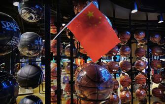 BEIJING, CHINA - OCTOBER 09: (Editor's Note: Photo taken with mobile phone camera.) A Chinese flag is seen placed on basketballs in the NBA flagship retail store on October 9, 2019 in Beijing, China. The NBA is trying to salvage its brand in China amid criticism of its handling of a controversial tweet that infuriated the government and has jeopardized the leagues Chinese expansion. The crisis, triggered by a Houston Rockets executives tweet that praised protests in Hong Kong, prompted the Chinese Basketball Association to suspend its partnership with the league. The backlash continued with state-owned television CCTV scrapping its plans to broadcast pre-season games in Shanghai and Shenzhen, and the cancellation of other promotional fan events.  The league issued an apology, though NBA Commissioner Adam Silver angered Chinese officials further when he defended the right of players and team executives to free speech. China represents a lucrative market for the NBA, which stands to lose millions of dollars in revenue and threatens to alienate Chinese fans.  Many have taken to Chinas social media platforms to express their outrage and disappointment that the NBA would question the countrys sovereignty over Hong Kong which has been mired in anti-government protests since June.(Photo by Kevin Frayer/Getty Images)