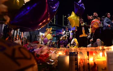 Fans gather in front of a makeshift memorial as they mourn the death of NBA legend Kobe Bryant, who was killed along with his daughter and seven others in a helicopter crash on January 26, at LA Live plaza in front of Staples Center in Los Angeles on January 27, 2020. - Federal investigators sifted through the wreckage of the helicopter crash that killed basketball legend Kobe Bryant and eight other people, hoping to find clues to what caused the accident that stunned the world. (Photo by Frederic J. BROWN / AFP) (Photo by FREDERIC J. BROWN/AFP via Getty Images)