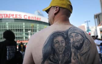 LOS ANGELES, CALIFORNIA - FEBRUARY 24: A man displays a Kobe and Gianna tattoo as fans depart from the ‚ÄòCelebration of Life for Kobe and Gianna Bryant‚Äô memorial service at the Staples Center on February 24, 2020 in Los Angeles, California. Los Angeles Lakers NBA star Kobe Bryant, 41, and his 13-year-old daughter Gianna were killed along with seven others in a helicopter crash near Los Angeles on January 26. (Photo by Mario Tama/Getty Images)