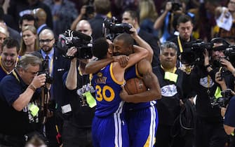 Golden State Warriors Stephen Curry (L) and MVP Andre Iguodala (R) celebrate their team defeating the Cleveland Cavaliers in Game 6 to win the 2015 NBA Finals June 16, 2015 at the Quicken Loans Arena in Cleveland, Ohio.  Curry and Iguodala each scored 25 points as the Golden State Warriors captured their first NBA title in 40 years by defeating Cleveland 105-97 to win the NBA Finals.    AFP PHOTO  / TIMOTHY A. CLARY        (Photo credit should read TIMOTHY A. CLARY/AFP via Getty Images)