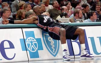 CHARLOTTE, NC - DECEMBER 2:  Utah Jazz's Karl Malone stretches at the scorer's table before entering the game during the second half of the, 02 December 2000, game against the Charlotte Hornets at Charlotte Coliseum in Charlotte, NC.  Malone is on the verge of passing Wilt Chamberlain for second place on the NBA all-time scoring list. Kareem Abdul-Jabbar is first in all-time scoring. Charlotte won the game 94-89.  (Photo credit should read ERIK PEREL/AFP via Getty Images)