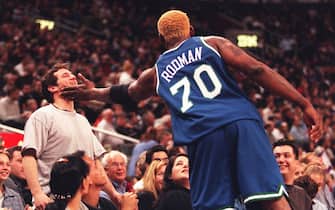 TORONTO, CANADA - FEBRUARY 20:  Dallas Maverick forward Dennis Rodman jokingly slaps a fan on the face during second quarter action against the Raptors in Toronto 22 February 2000. The man, who was yelling insults at Rodman, finally caught his attention.  (Photo credit should read JOHN HRYNIUK/AFP via Getty Images)
