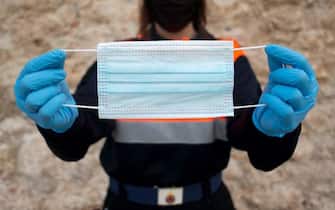 TOPSHOT - Spanish Civil Protection member Merche poses with a face mask during a distribution in Ronda on April 13, 2020 as some companies were set to resume operations at the end of a two-weeks halt of all non-essential activity amid a national lockdown to stop the spread of the COVID-19 coronavirus. - The death toll from the coronavirus pandemic has slowed in some of the worst-hit countries, with Spain readying to reopen parts of its economy as governments grapple with a once-in-a-century recession. (Photo by JORGE GUERRERO / AFP) (Photo by JORGE GUERRERO/AFP via Getty Images)