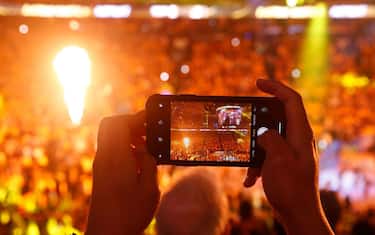 OAKLAND, CALIFORNIA - JUNE 07: A fan uses his iPhone to take a photo of player introductions prior to Game Four of the 2019 NBA Finals between the Golden State Warriors and the Toronto Raptors at ORACLE Arena on June 07, 2019 in Oakland, California. NOTE TO USER: User expressly acknowledges and agrees that, by downloading and or using this photograph, User is consenting to the terms and conditions of the Getty Images License Agreement. (Photo by Lachlan Cunningham/Getty Images)