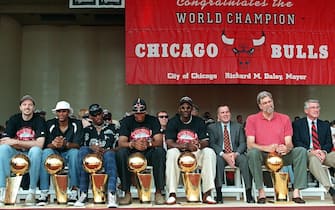 CHICAGO, IL - JUNE 16:  From left, Chicago Bulls players Toni Kukoc, Ron Harper, Dennis Rodman, Scottie Pippen, and Michael Jordan sit with Chicago Mayor Richard Daley, Bulls head coach Phil Jackson and Illinois Governor Jim Edgar at the team's NBA championship rally in Chicago, IL 16 June. In the NBA Finals, the Bulls defeated the Utah Jazz four-games-to-two to win their third straight title and their sixth in eight years.  (Photo credit should read PETER PAWINSKI/AFP via Getty Images)
