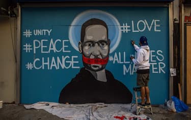 The artist Celos paints a mural in Downtown Los Angeles on May 30, 2020 in protest against the death of George Floyd, an unarmed black man who died while while being arrested and pinned to the ground by the knee of a Minneapolis police officer. - Clashes broke out and major cities imposed curfews as America began another night of unrest Saturday with angry demonstrators ignoring warnings from President Donald Trump that his government would stop violent protests over police brutality "cold." (Photo by Apu GOMES / AFP) / RESTRICTED TO EDITORIAL USE - MANDATORY MENTION OF THE ARTIST UPON PUBLICATION - TO ILLUSTRATE THE EVENT AS SPECIFIED IN THE CAPTION (Photo by APU GOMES/AFP via Getty Images)