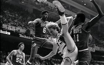 516489610 (Original Caption) Celtics' Larry Bird (center) trying to score, does a high leg split as he is hit by 76ers' Caldwell Jones (right), in 1st quarter action of the first game of the NBA semi-final playoffs at Boston Garden (4/18). 76ers' Julius Erving (6) and Steve Mix (50) are also in the photo.
