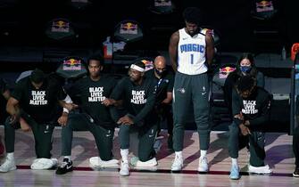 LAKE BUENA VISTA, FL - JULY 31: Jonathan Isaac #1 of the Orlando Magic stands as others kneel before the start of a game between the Brooklyn Nets and the Orlando Magic on July 31, 2020 at The HP Field House at ESPN Wide World Of Sports Complex in Lake Buena Vista, Florida. NOTE TO USER: User expressly acknowledges and agrees that, by downloading and/or using this Photograph, user is consenting to the terms and conditions of the Getty Images License Agreement. (Photo by Ashley Landis - Pool/Getty Images)