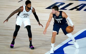 Dallas Mavericks' Luka Doncic (77) works the floor against Los Angeles Clippers' Paul George (13) during the first half of an NBA basketball game Thursday, Aug. 6, 2020 in Lake Buena Vista, Fla. (AP Photo/Ashley Landis, Pool)