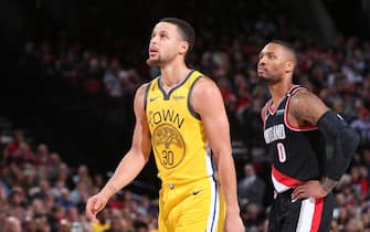 PORTLAND, OR - FEBRUARY 13: Stephen Curry #30 of the Golden State Warriors and Damian Lillard #0 of the Portland Trail Blazers look on during the game on February 13, 2019 at the Moda Center in Portland, Oregon. NOTE TO USER: User expressly acknowledges and agrees that, by downloading and/or using this photograph, user is consenting to the terms and conditions of the Getty Images License Agreement. Mandatory Copyright Notice: Copyright 2019 NBAE (Photo by Sam Forencich/NBAE via Getty Images)