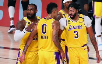 LAKE BUENA VISTA, FLORIDA - AUGUST 20:  LeBron James #23, Kyle Kuzma #0 and Anthony Davis #3 of the Los Angeles Lakers huddle during the first half in game two of the first round of the NBA playoffs at AdventHealth Arena at ESPN Wide World Of Sports Complex on August 20, 2020 in Lake Buena Vista, Florida. NOTE TO USER: User expressly acknowledges and agrees that, by downloading and or using this photograph, User is consenting to the terms and conditions of the Getty Images License Agreement. (Photo by Kim Klement-Pool/Getty Images)