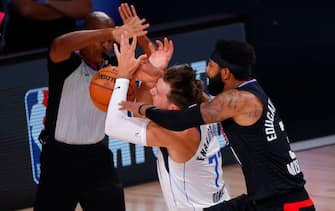 LAKE BUENA VISTA, FLORIDA - AUGUST 30: Marcus Morris Sr. #31 of the LA Clippers fouls Luka Doncic #77 of the Dallas Mavericks  during the first quarter in Game Six of the Western Conference First Round during the 2020 NBA Playoffs at AdventHealth Arena at ESPN Wide World Of Sports Complex on August 30, 2020 in Lake Buena Vista, Florida. Morris was ejected from the game after the play. NOTE TO USER: User expressly acknowledges and agrees that, by downloading and or using this photograph, User is consenting to the terms and conditions of the Getty Images License Agreement. (Photo by Kevin C. Cox/Getty Images)