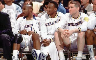 OAKLAND, CA - 1989: (L) Tim Hardaway #10, (C) Mitch Richmond #23 and (R) Chris Mullin #17 of the Golden State Warriors sit on the bench during a game played in 1989 at the Oakland-Alameda Coliseum in Oakland, California. NOTE TO USER: User expressly acknowledges that, by downloading and or using this photograph, User is consenting to the terms and conditions of the Getty Images License agreement. Mandatory Copyright Notice: Copyright 1989 NBAE (Photo by NBA Photos/NBAE via Getty Images)