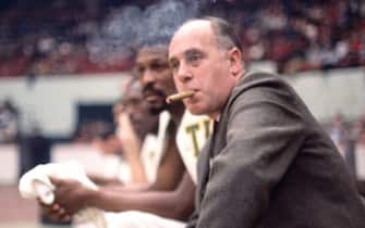 BOSTON - 1965:  Red Auerbach, haed coach of the Boston Celticcs smokes a cigar on the bench during a game played in 1965 at the Boston Garden in Boston, Massachusetts. NOTE TO USER: User expressly acknowledges and agrees that, by downloading and or using this photograph, User is consenting to the terms and conditions of the Getty Images License Agreement. Mandatory Copyright Notice: Copyright 1965 NBAE (Photo by Dick Raphael/NBAE via Getty Images)