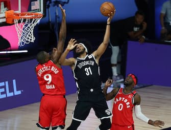 LAKE BUENA VISTA, FLORIDA - AUGUST 23:  Jarrett Allen #31 of the Brooklyn Nets shoots a basket against the Serge Ibaka #9 and Terence Davis #0 of the Toronto Raptors during the first half in game four of the first round of the NBA playoffs at The Field House at ESPN Wide World Of Sports Complex on August 23, 2020 in Lake Buena Vista, Florida. NOTE TO USER: User expressly acknowledges and agrees that, by downloading and or using this photograph, User is consenting to the terms and conditions of the Getty Images License Agreement.  (Photo by Kim Klement-Pool/Getty Images)