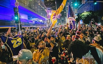 LOS ANGELES, CA - OCTOBER 11: Lakers fans celebrate in front of the Staples Center on October 11, 2020 in Los Angeles, California. People gathered to celebrate after the Los Angeles Lakers defeated the Miami Heat in game 6 of the NBA finals. (Photo by Brandon Bell/Getty Images)