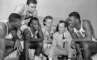 (Original Caption) A quintet of players from the University of San Francisco take time out during practice to join in a little close harmony. They are (left to right): Mike Farmer; Bill Russell; Carl Boldt; K.C. Jones; and Hal Perry at the Piano. The San Francisco Dons have something to sing about-- they swept away all competitors to win their second straight National collegiate basketball title. The Dons became the first team in N.C.A.A. history to win the crown after having an unbeaten season.