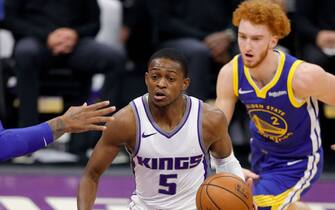 SACRAMENTO, CALIFORNIA - DECEMBER 15:  De'Aaron Fox #5 of the Sacramento Kings dribbles past Nico Mannion #2 of the Golden State Warriors at Golden 1 Center on December 15, 2020 in Sacramento, California.  NOTE TO USER: User expressly acknowledges and agrees that, by downloading and or using this photograph, User is consenting to the terms and conditions of the Getty Images License Agreement.  (Photo by Ezra Shaw/Getty Images)