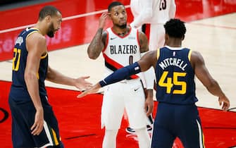 PORTLAND, OREGON - DECEMBER 23:  Rudy Gobert #27 and Donovan Mitchell #45 of the Utah Jazz high five in front of Damian Lillard #0 of the Portland Trail Blazers after a foul during the second quarter at Moda Center on December 23, 2020 in Portland, Oregon. NOTE TO USER: User expressly acknowledges and agrees that, by downloading and or using this photograph, User is consenting to the terms and conditions of the Getty Images License Agreement. (Photo by Steph Chambers/Getty Images)