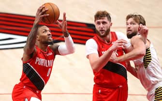 1296431332 PORTLAND, OREGON - JANUARY 14: Damian Lillard #0 takes a shot alongside Jusuf Nurkic #27 of the Portland Trail Blazers and Domantas Sabonis #11 of the Indiana Pacers in the third quarter at Moda Center on January 14, 2021 in Portland, Oregon. NOTE TO USER: User expressly acknowledges and agrees that, by downloading and or using this photograph, User is consenting to the terms and conditions of the Getty Images License Agreement. (Photo by Abbie Parr/Getty Images)