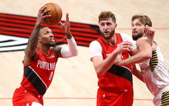 PORTLAND, OREGON - JANUARY 14: Damian Lillard #0 takes a shot alongside Jusuf Nurkic #27 of the Portland Trail Blazers and Domantas Sabonis #11 of the Indiana Pacers in the third quarter at Moda Center on January 14, 2021 in Portland, Oregon. NOTE TO USER: User expressly acknowledges and agrees that, by downloading and or using this photograph, User is consenting to the terms and conditions of the Getty Images License Agreement. (Photo by Abbie Parr/Getty Images)