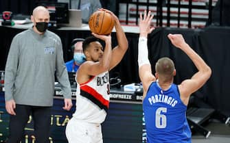 PORTLAND, OREGON - MARCH 19: CJ McCollum #3 of the Portland Trail Blazers shoots a three point basket against Kristaps Porzingis #6 of the Dallas Mavericks during the fourth quarter at Moda Center on March 19, 2021 in Portland, Oregon. NOTE TO USER: User expressly acknowledges and agrees that, by downloading and or using this photograph, User is consenting to the terms and conditions of the Getty Images License Agreement. (Photo by Steph Chambers/Getty Images)