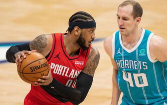 CHARLOTTE, NORTH CAROLINA - APRIL 18: Carmelo Anthony #00 of the Portland Trail Blazers is guarded by Cody Zeller #40 of the Charlotte Hornets in the first quarter at Spectrum Center on April 18, 2021 in Charlotte, North Carolina. NOTE TO USER: User expressly acknowledges and agrees that, by downloading and or using this photograph, User is consenting to the terms and conditions of the Getty Images License Agreement. (Photo by Jacob Kupferman/Getty Images)