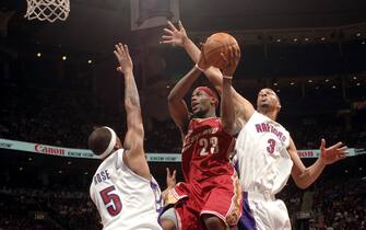 52459515 TORONTO - MARCH 20: LeBron James #23 of the Cleveland Cavaliers drives the lane against Jalen Rose #5 and Loren Woods #3 of the Toronto Raptors on March 20, 2005 at the Air Canada Centre in Toronto, Canada. NOTE TO USER: User expressly acknowledges and agrees that, by downloading and or using this Photograph, user is consenting to the terms and conditions of the Getty Images License Agreement. Mandatory Copyright Notice: Copyright 2005 NBAE (Photo by Ron Turenne/NBAE via Getty Images)