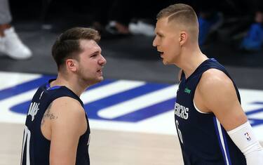 DALLAS, TEXAS - MAY 28:  Luka Doncic #77 and Kristaps Porzingis #6 of the Dallas Mavericks react against the LA Clippers in the first quarter in game three of the Western Conference first round series at American Airlines Center on May 28, 2021 in Dallas, Texas.  NOTE TO USER: User expressly acknowledges and agrees that, by downloading and or using this photograph, User is consenting to the terms and conditions of the Getty Images License Agreement. (Photo by Ronald Martinez/Getty Images)