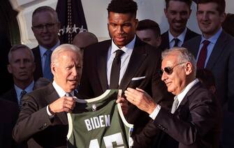 WASHINGTON, DC - NOVEMBER 08: U.S. President Joe Biden (L) receive a jersey from Milwaukee Bucks owner Marc Lasry (R) as player Giannis Antetokounmpo (C) watches during an event where Biden honored the Bucks for winning the 2021 NBA Championship, on the South Lawn at the White House on November 08, 2021 in Washington, DC. The Bucks defeated the Phoenix Suns to win the 2021 NBA Championship. (Photo by Win McNamee/Getty Images)