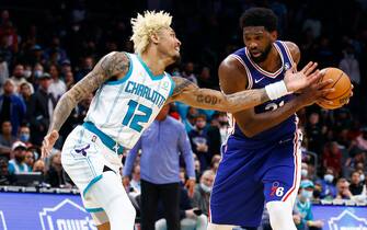CHARLOTTE, NORTH CAROLINA - DECEMBER 06: Joel Embiid #21 of the Philadelphia 76ers is guarded by Kelly Oubre Jr. #12 of the Charlotte Hornets during overtime of the game at Spectrum Center on December 06, 2021 in Charlotte, North Carolina. NOTE TO USER: User expressly acknowledges and agrees that, by downloading and or using this photograph, User is consenting to the terms and conditions of the Getty Images License Agreement. (Photo by Jared C. Tilton/Getty Images)