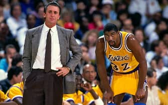 INGLEWOOD, CA - 1989: Head Coach Pat Riley and Magic Johnson #32 of the Los Angeles Lakers look on during a game circa 1989 at The Forum in Inglewood, California. NOTE TO USER: User expressly acknowledges and agrees that, by downloading and/or using this photograph, user is consenting to the terms and conditions of the Getty Images License Agreement. Mandatory Copyright Notice: Copyright 1989 NBAE (Photo by Andrew D. Bernstein/NBAE via Getty Images)