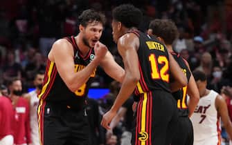 MIAMI, FLORIDA - JANUARY 14: Danilo Gallinari #8 of the Atlanta Hawks speaks with De'Andre Hunter #12 and Trae Young #11 during a break in play against the Miami Heat in the second half at FTX Arena on January 14, 2022 in Miami, Florida. NOTE TO USER: User expressly acknowledges and agrees that, by downloading and or using this photograph, User is consenting to the terms and conditions of the Getty Images License Agreement. (Photo by Mark Brown/Getty Images)