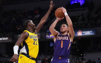 INDIANAPOLIS, INDIANA - JANUARY 14: Devin Booker #1 of the Phoenix Suns attempts a shot while being guarded by Caris LeVert #22 of the Indiana Pacers in the second quarter at Gainbridge Fieldhouse on January 14, 2022 in Indianapolis, Indiana. NOTE TO USER: User expressly acknowledges and agrees that, by downloading and or using this Photograph, user is consenting to the terms and conditions of the Getty Images License Agreement. (Photo by Dylan Buell/Getty Images)