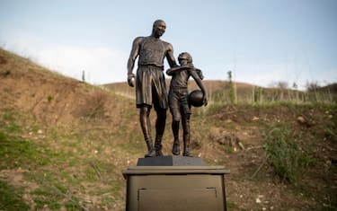 CALABASAS, CA - JANUARY 26: Artist Dan Medina's bronze sculpture depicting Kobe Bryant, daughter Gianna Bryant, and the names of those who died in a helicopter crash in 2020 is seen during a one-day temporary memorial display in Calabasas, California, on January 26, 2022. Retired Los Angeles Lakers star Kobe Bryant died along with his daughter Gianna in a helicopter crash that killed nine people on January 26, 2020. The sculpture was temporarily placed at the site of the crash. (Photo by Josh Lefkowitz/Getty Images)