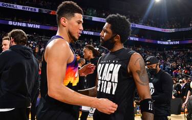 PHOENIX, AZ - FEBRUARY 1: Devin Booker #1 of the Phoenix Suns and Kyrie Irving #11 of the Brooklyn Nets embrace after the game on February 1, 2022 at Footprint Center in Phoenix, Arizona. NOTE TO USER: User expressly acknowledges and agrees that, by downloading and or using this photograph, user is consenting to the terms and conditions of the Getty Images License Agreement. Mandatory Copyright Notice: Copyright 2022 NBAE (Photo by Barry Gossage/NBAE via Getty Images)
