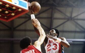 PISCATAWAY, NJ - CIRCA 1975: John Williamson #23 of the New Jersey Nets shots against Henry Bibby #14 of the Philadelphia 76ers during a game played circa 1975 at the Rutgers Athletic Center in Piscataway, New Jersey. NOTE TO USER: User expressly acknowledges and agrees that, by downloading and or using this photograph, User is consenting to the terms and conditions of the Getty Images License Agreement. Mandatory Copyright Notice: Copyright 1975 NBAE (Photo by Ron Koch/NBAE via Getty Images)