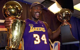 PHILADELPHIA, UNITED STATES:  Shaquille O'Neal holds the MVP trophy (R) and the Larry O'Brian Championship trophy (L) after the Los Angeles Lakers won game five of the NBA Finals against the Philadelphia 76ers 15 June, 2001 at First Union Center in Philadelphia, PA. The Lakers won the game 108-96 to win the best-of-seven game series 4-1.  AFP PHOTO  Stan HONDA (Photo credit should read STAN HONDA/AFP via Getty Images)