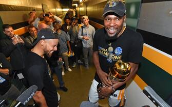 OAKLAND, CA - JUNE 12:  Kevin Durant #35 and Stephen Curry #30 of the Golden State Warriors celebrate in the hallway after winning the NBA Championship in Game Five of the 2017 NBA Finals against the Cleveland Cavaliers on June 12, 2017 at ORACLE Arena in Oakland, California. NOTE TO USER: User expressly acknowledges and agrees that, by downloading and/or using this photograph, user is consenting to the terms and conditions of Getty Images License Agreement. Mandatory Copyright Notice: Copyright 2017 NBAE (Photo by Andrew D. Bernstein/NBAE via Getty Images)