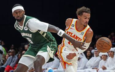 Atlanta Hawks' guard Trae Young (R) dribbles past Milwaukee Bucks' forward Bobby Portis during the NBA pre-season basketball match between the Milwaukee Bucks and the Atlanta Hawks at the Etihad Arena on Yas Island in Abu Dhabi, on October 8, 2022. (Photo by Giuseppe CACACE / AFP) (Photo by GIUSEPPE CACACE/AFP via Getty Images)
