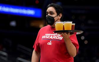 WASHINGTON, DC - OCTOBER 09: A server carries a tray of beer at the game between the Washington Wizards and the New York Knicks at Capital One Arena on October 09, 2021 in Washington, DC. NOTE TO USER: User expressly acknowledges and agrees that, by downloading and or using this photograph, User is consenting to the terms and conditions of the Getty Images License Agreement.  (Photo by G Fiume/Getty Images)