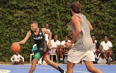 Paris Saint-Germain and France national football team star striker Kylian Mbappe (L) plays basketball with former professional basketball player Joakim Noah  (R) at the Club Noah sports complex in Yaounde on July 7, 2023 during a charity visit and a tour of his father's village. (Photo by Daniel BELOUMOU OLOMO / AFP) (Photo by DANIEL BELOUMOU OLOMO/AFP via Getty Images)