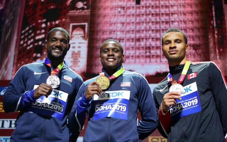 Christian Coleman mostra la medaglia d'oro vinta ai Mondiali di Doha. Con lui nella foto anche Justin Gatlin e Andre De Grasse