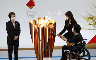 epa09095165 Tokyo 2020 Organising Committee President Seiko Hashimoto (L) looks on as actor Satomi Hishihara (R,back) and Paralyimpian Aki Taguchi light the celebration cauldron on the first day of the Tokyo 2020 Olympic torch relay in Naraha, Fukushima prefecture, Japan, 25 March 2021.  EPA/KIM KYUNG-HOON / POOL