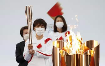 epa09095195 The torch is prepared to be lit during the Tokyo 2020 Olympic Torch Relay Grand Start in Naraha, Fukushima prefecture, Japan, 25 March 2021. The postponed Tokyo 2020 Olympic Games are scheduled to start on 23 July 2021 and some 10,000 torchbearers will run across the country along a 121-day journey.  EPA/KIM KYUNG-HOON / POOL