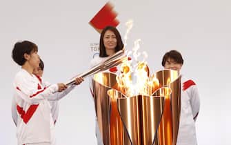 epa09095217 The Olympic torch is lit by a member of Japan's women's national soccer team Nadeshiko Japan during the Tokyo 2020 Olympic Torch Relay Grand Start in Naraha, Fukushima prefecture, Japan, 25 March 2021. The postponed Tokyo 2020 Olympic Games are scheduled to start on 23 July 2021 and some 10,000 torchbearers will run across the country along a 121-day journey.  EPA/KIM KYUNG-HOON / POOL